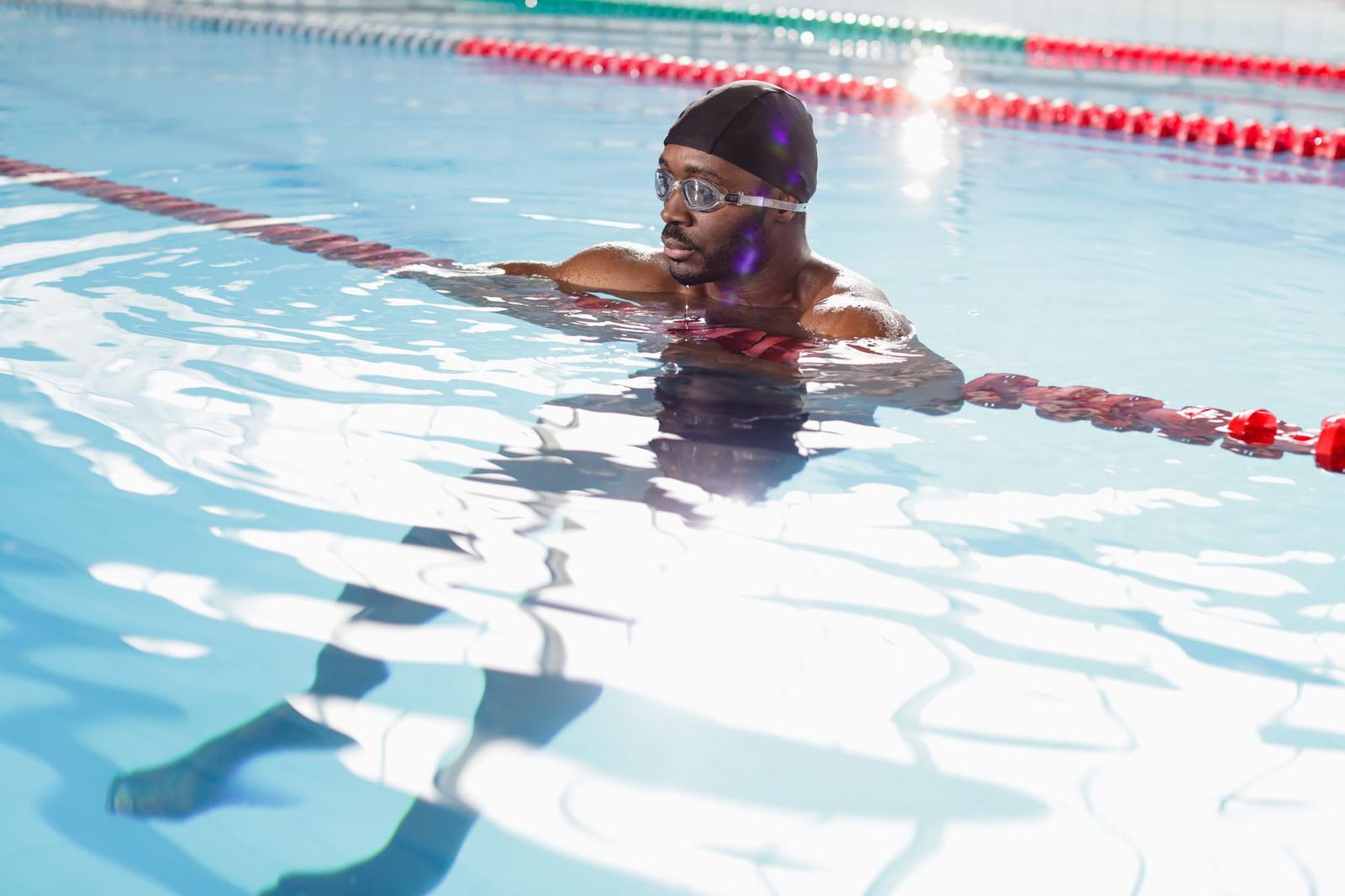 Man Swimming in the Pool Holding the Divider Rope